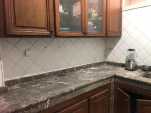a kitchen with a counter top and wooden cabinets at Captivating 4-Bed House in Tamaris in Tamaris