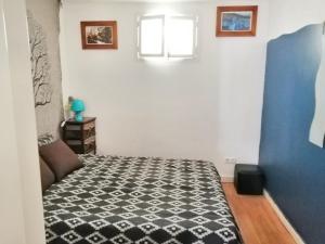 a bedroom with a bed with a black and white comforter at One bedroom apartement with wifi at Lisboa 5 km away from the beach in Lisbon