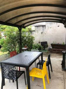 een zwarte tafel en stoelen onder een paraplu bij Ibis Rouge in Villars-les-Dombes