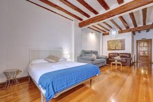 パンプローナにあるCasa Iruña by Clabaoのベッドとソファと椅子のある寝室