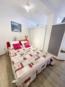プラ・ド・モロ・ラ・プレストにあるAppartement d'une chambre avec terrasse amenagee a Prats de Mollo la Presteのベッドルーム1室(大型ベッド1台、赤い枕付)