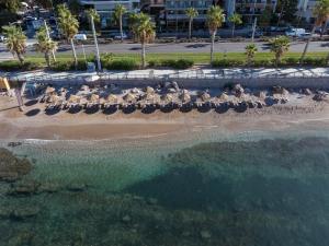 una vista aérea de una playa con sillas y el océano en Coral Hotel Athens, en Atenas