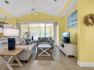 a living room with a couch and a tv at Caribbean Breeze by Newman-Dailey in Destin