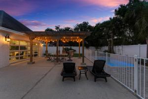 a patio with chairs and a table and a fence at A World Away by Newman-Dailey in Destin +47 photos