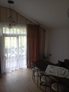 d'une salle à manger avec une table, des chaises et une fenêtre. dans l'établissement U Anastasii i Sofii bilya richki, à Mykulychyn