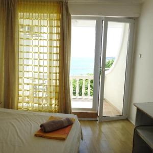 a bedroom with a bed and a large sliding glass door at Riviera Beach Hotel in Sozopol