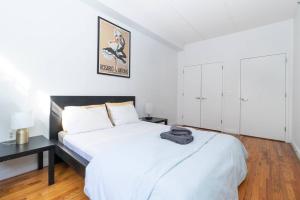 a bedroom with a large white bed with a black headboard at Central Park North - Quiet Place in New York