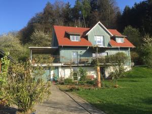 una casa grande con techo naranja en Gemütliche Wohnung mit Terrasse in der Nähe vom Bodensee, en Tettnang