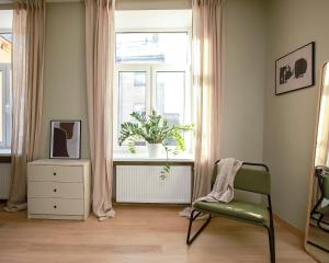 a room with a chair and a window with a plant at Design apartments between National Art Museum and Arena Riga in Rīga