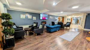 una sala d'attesa con divano e sedie blu di Inn On The Coast a Portrush