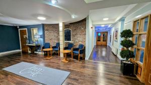a waiting room with blue chairs and a table at Inn On The Coast in Portrush