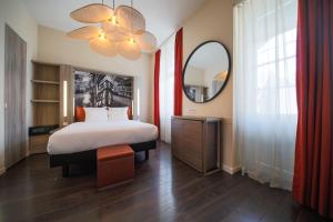 ストラスブールにあるAparthotel Adagio Strasbourg Place Kleberのベッドルーム(大型ベッド1台、鏡付)