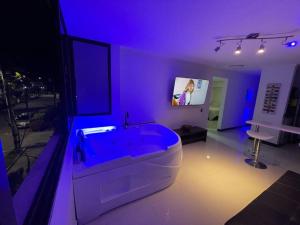 a large bathroom with a tub with blue lighting at Laureles best location with Jacuzzi and AC in Medellín
