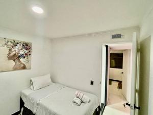 a white room with a bed and a mirror at Laureles best location with Jacuzzi and AC in Medellín