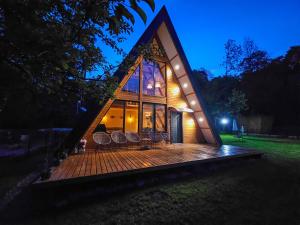 Una pequeña casa con terraza por la noche. en Casuta Floare de Mar, en Trăisteni