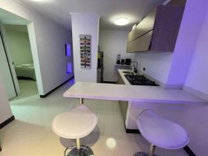 a kitchen with two stools and a counter with purple at Laureles best location with Jacuzzi and AC in Medellín