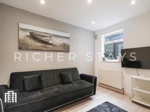 a living room with a couch and a tv at Large Home for Contractors & Families - Garden & Amenities in London