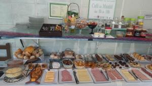 un buffet de différents types de nourriture sur une table dans l'établissement Pousada Catavento, à Arraial d'Ajuda