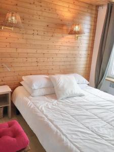 a bed in a room with a wooden wall at Appartement d'une chambre avec vue sur la mer et wifi a Granville in Granville