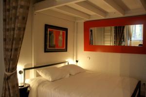 a bedroom with a white bed and a mirror at Appart' Fleurieu in Lyon