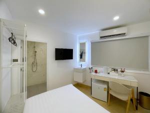 a white bathroom with a sink and a shower at Arawana Express Sukhumvit 22 in Bangkok