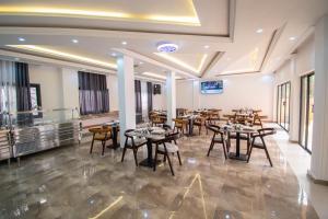 ein Restaurant mit Tischen und Stühlen in einem Raum in der Unterkunft Hôtel TAZ PLUS in Kribi