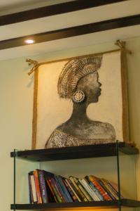 un busto de una mujer en un estante con libros en Getaway Experience Villa., en Dar es Salaam