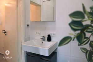 a bathroom with a white sink and a mirror at Ambergs Turmjuwel, Zentral und Chic in Amberg +5 photos