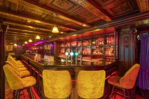 a bar with yellow bar stools in a room at Skeffington Arms Hotel in Galway