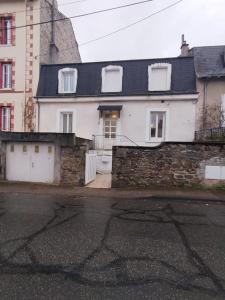 een wit huis met een zwart dak en een gebouw bij appartement 2 Pièces in Limoges