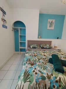 een slaapkamer met een bed en een blauwe muur bij appartement 2 Pièces in Limoges