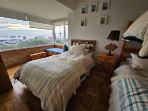 een slaapkamer met 2 bedden en een groot raam bij Departamento Frente al Mar in Viña del Mar