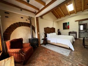 PuemboにあるHacienda Jimenita Wildlife Reserveのベッドルーム1室(ベッド1台、椅子1脚付)