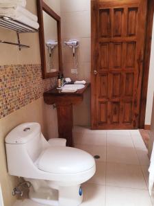 łazienka z toaletą, umywalką i drzwiami w obiekcie Hacienda Jimenita Wildlife Reserve w mieście Puembo