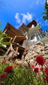 ein Haus mit einem Haufen Steine und roten Blumen in der Unterkunft La Aldea Zipolite in Zipolite