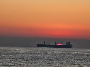 Departamento Frente al Mar في فينيا ديل مار: قارب كبير في المحيط عند غروب الشمس