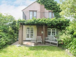 a house with two chairs in front of it at The Cottage in Watchet