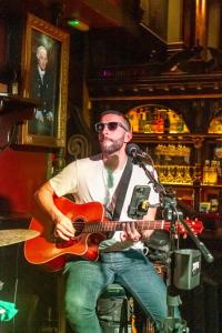 a man is playing a guitar in a bar at Skeffington Arms Hotel in Galway