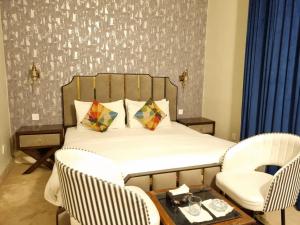 a bedroom with a bed with two chairs and a table at The Life Style Lodges opp Centaurus Mall in Islamabad