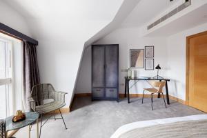 een slaapkamer met een bed, een bureau en een stoel bij Sonder Edgware Road in Londen