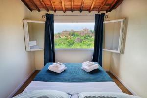 1 dormitorio con ventana y 2 toallas en una cama en I Merli di Ada, en Siena