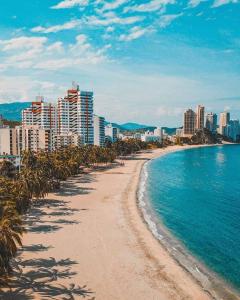 a beach in front of a city with tall buildings at Hotel Casa Telma in Santa Marta