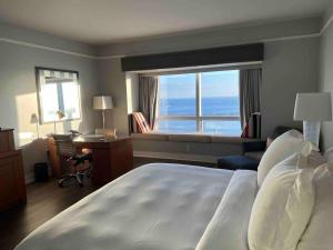 um quarto de hotel com uma cama, uma secretária e uma janela em Private condo hotel at Four Seasons Brickell em Miami