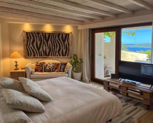 a bedroom with a large bed and a television at Villa Khepri in Porto Rotondo