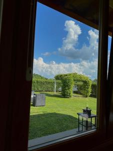 een raam met uitzicht op een tuin met een boog en een tafel bij Holiday Home Sovenigo in Puegnago