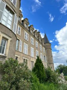 ein altes Gebäude mit einem Turm darauf in der Unterkunft Chambre de Princesse avec Grande Salle de Bain in Blet