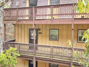 a apartment building with a deck with a dog on it at Hänsel and Gretel's Hideaway End Unit Parking! in Beech Mountain