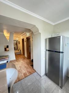 uma cozinha com um frigorífico de aço inoxidável num quarto em Warm Flat em Gonio