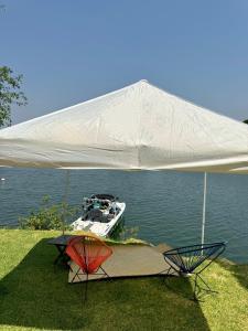 een boot in het water onder een witte tent bij La Calita de Teques in Tequesquitengo