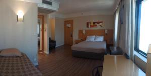 a hotel room with a bed and a window at Hotel Flat Guarulhos Apto1411 in Guarulhos